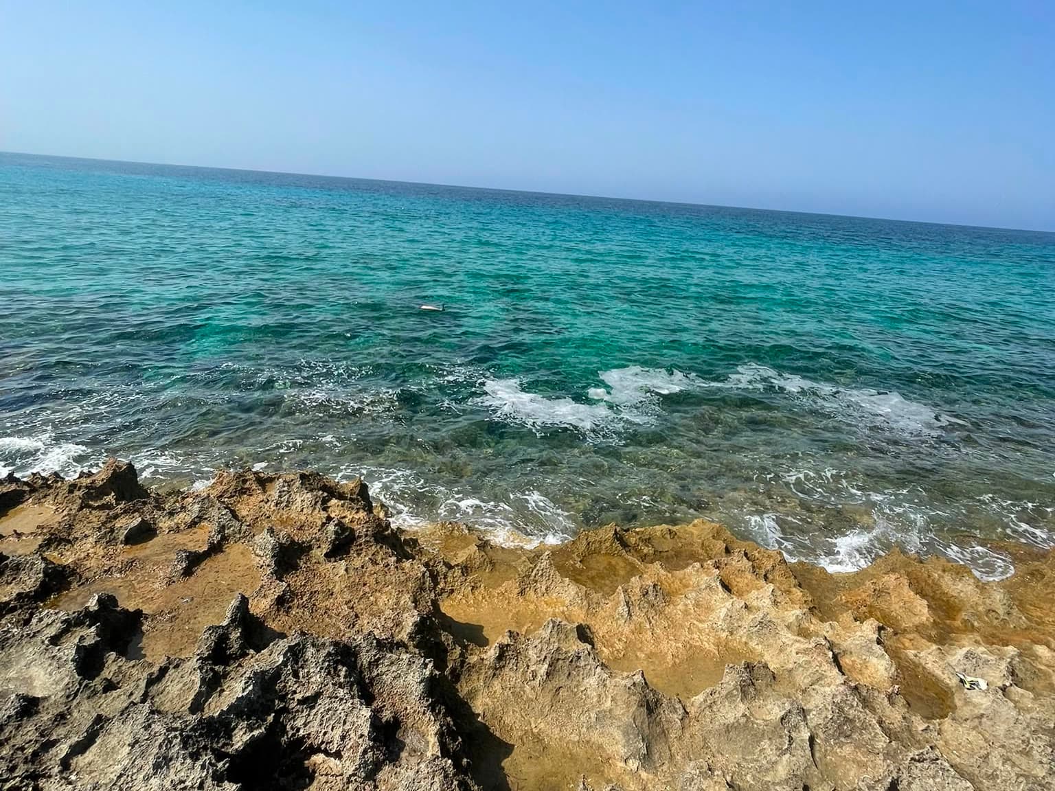 La scogliera e il mare turchese, con l'orizzonte in alto