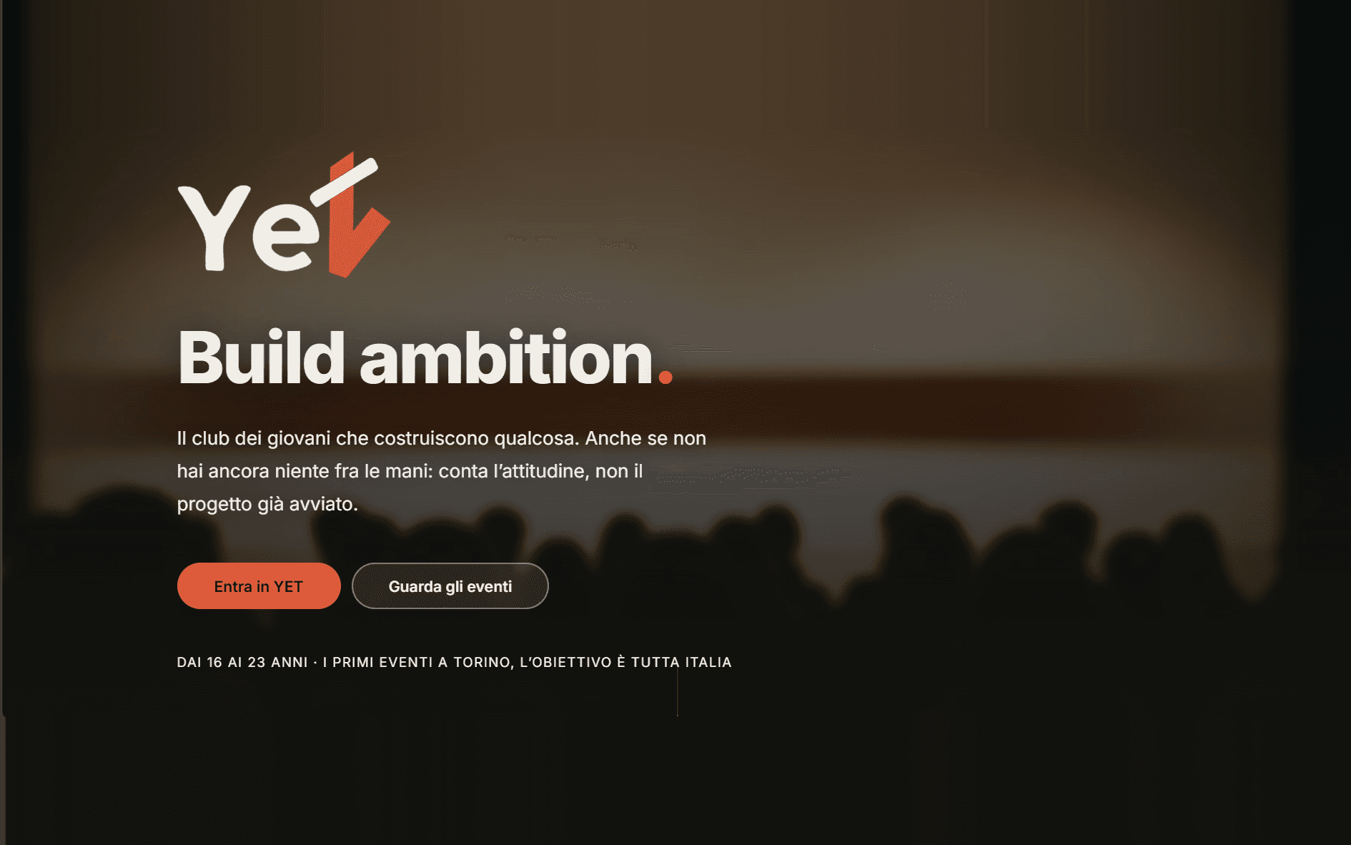 La home di YET: il marchio, il titolo «Build ambition.» e i due pulsanti Entra in YET e Guarda gli eventi, su una foto di platea